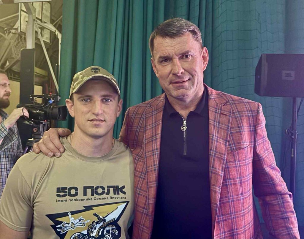 Чоловіки на фото, один у військовій футболці.