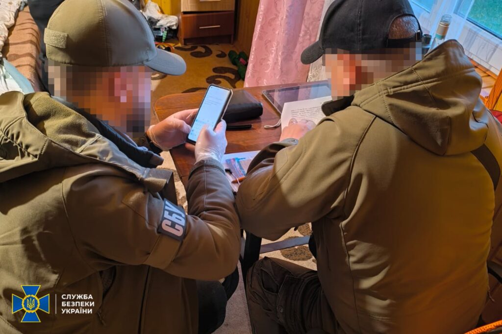 Люди працюють з документами та телефоном у кімнаті.