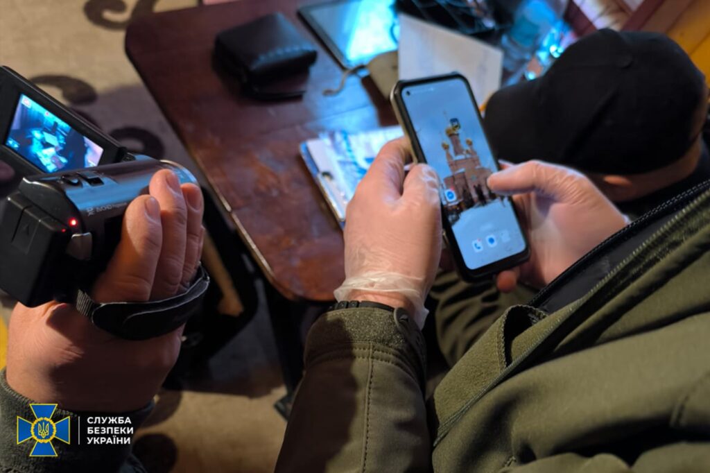 Службовець документує дані на смартфон і камеру.