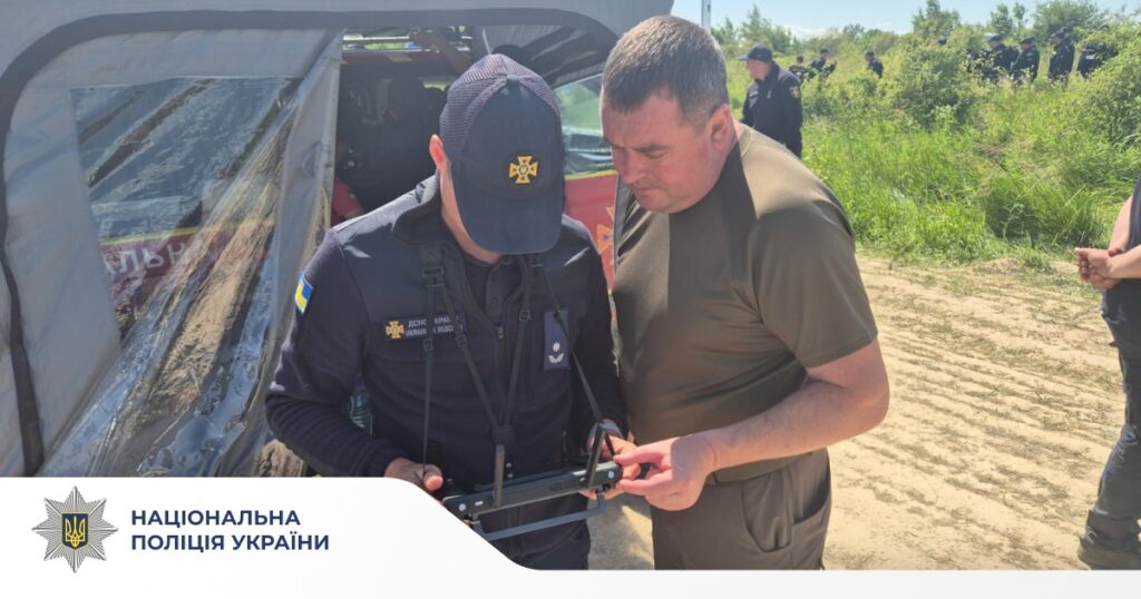 Двоє чоловіків оглядають обладнання на місцевості.