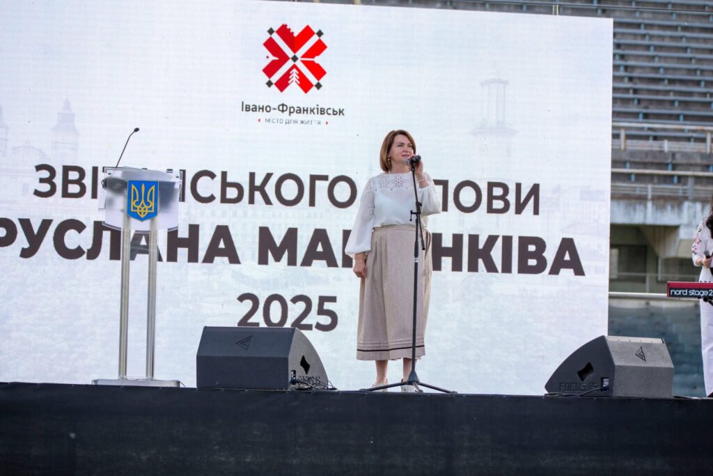 Жінка виступає на сцені з мікрофоном.