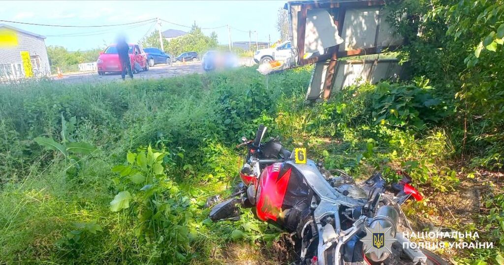 Аварія: мотоцикл та автомобіль на узбіччі.