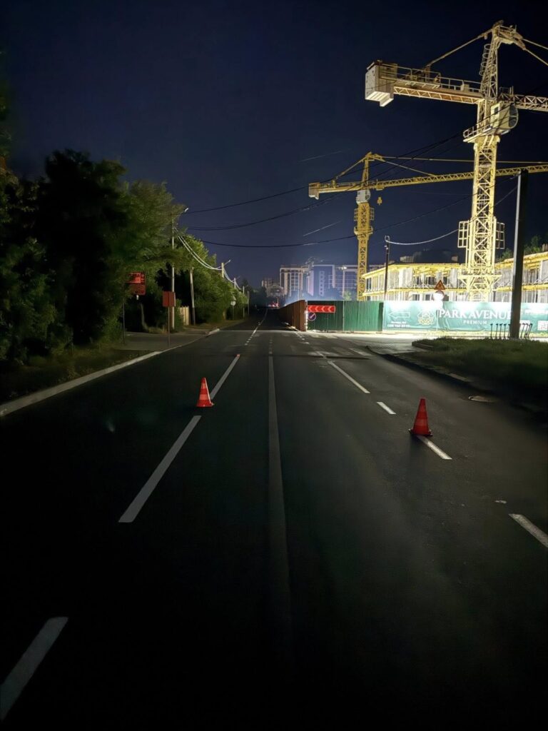 Нічна дорога, загороджена конусами, поруч будівництво