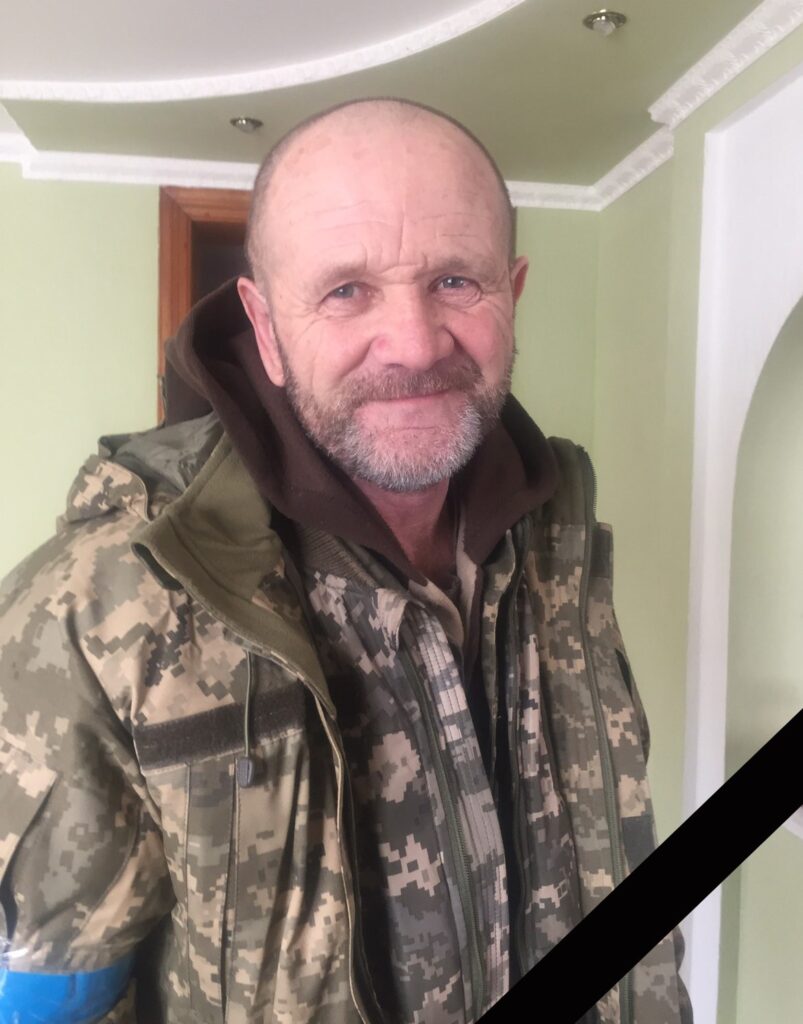 Чоловік у камуфляжній формі в приміщенні.