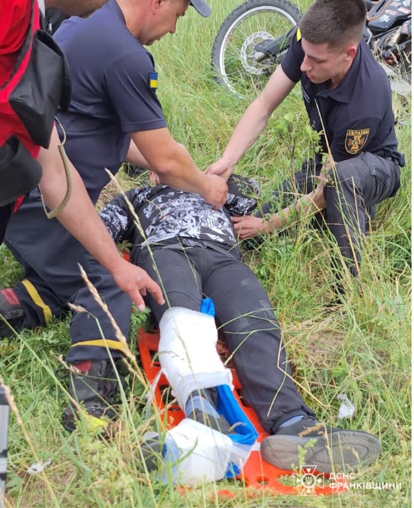 Рятувальники допомагають травмованому чоловіку на полі.