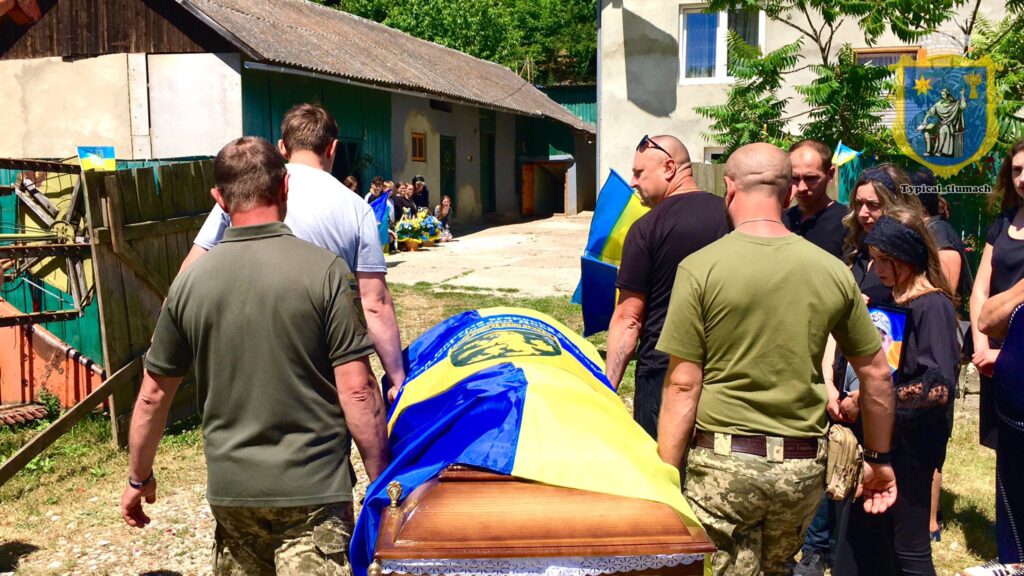 Прощання з прапором України, люди несуть труну.