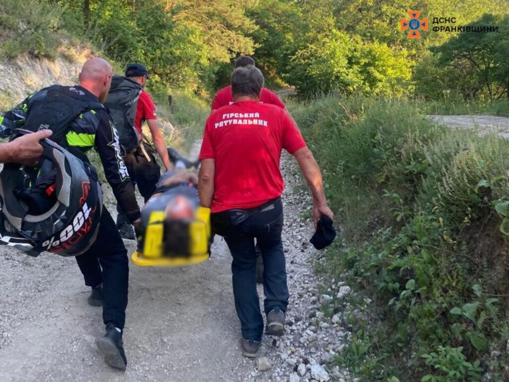 Рятувальники несуть постраждалого на ношах у горах.