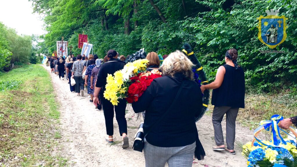 Люди несуть квіти під час ходи на природі.