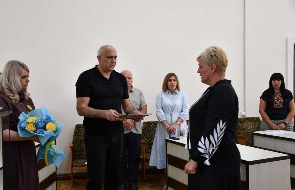 Збори людей у кімнаті з квітами та документами