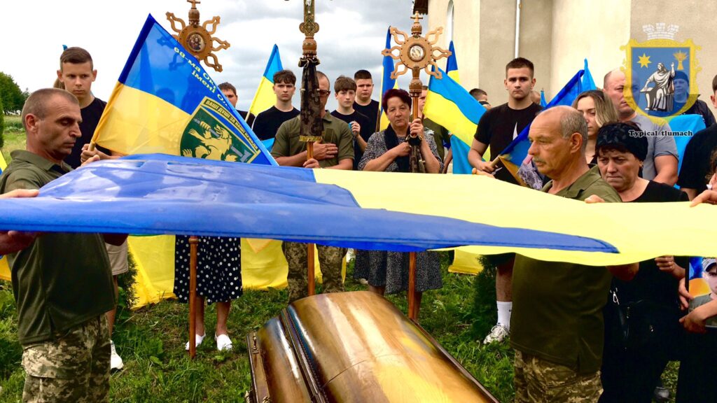 Церемонія з прапорами України і групою людей.