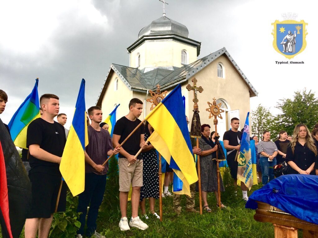 Люди із прапорами України біля церкви