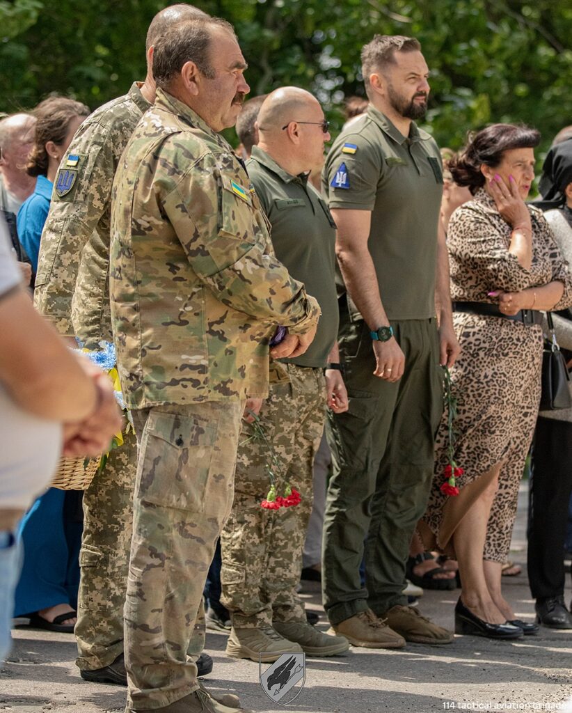 Люди в формі з квітами на вулиці.