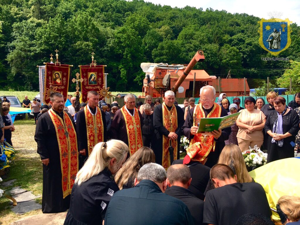 Священики на церемонії з іконами і прапорами.