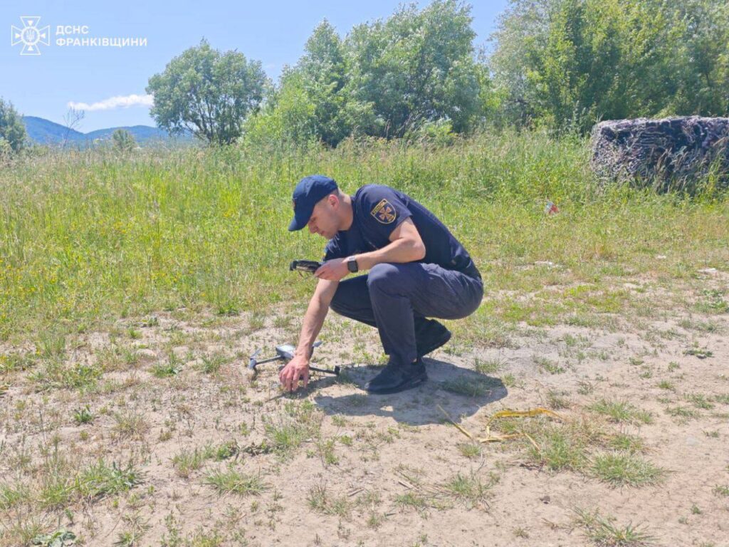 Пожежник управляє дроном на лісовій місцевості.