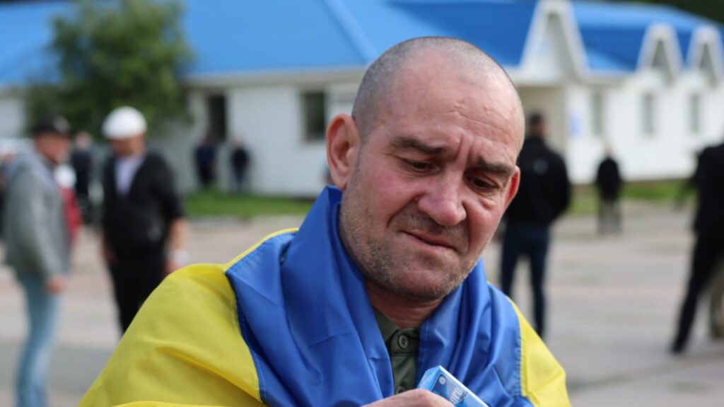 Чоловік у синьо-жовтому одязі на вулиці.