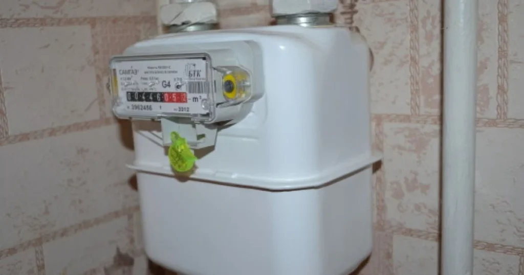 Газовий лічильник на стіні з плиткою.