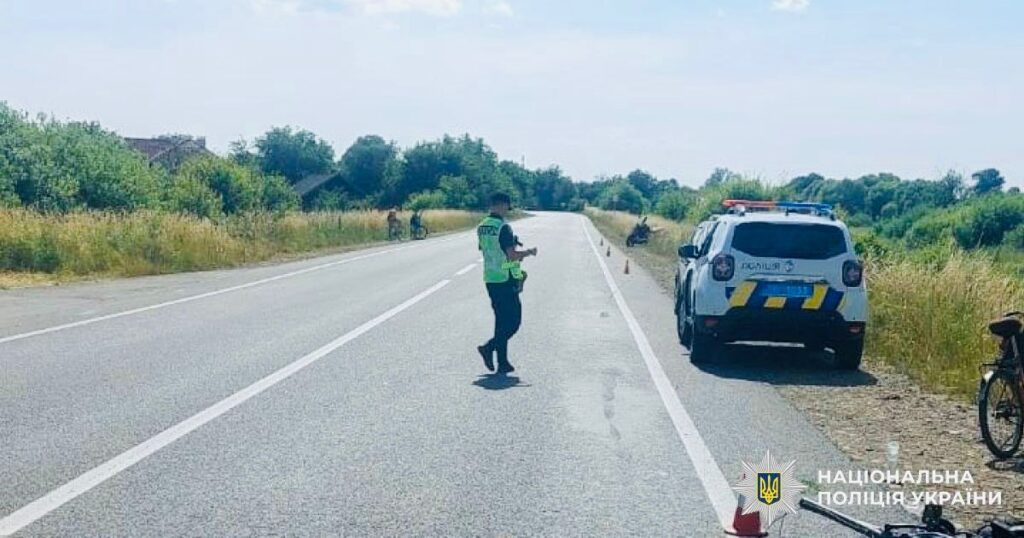 Поліцейський біля дороги з авто поруч