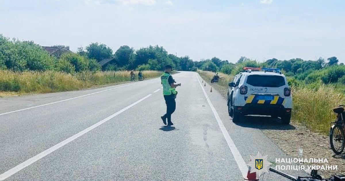 Поліцейський біля дороги з авто поруч
