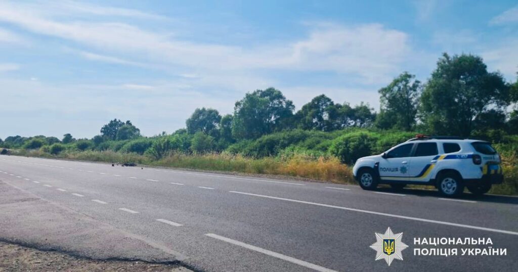 Дорожня патрульна машина на трасі біля лісу.