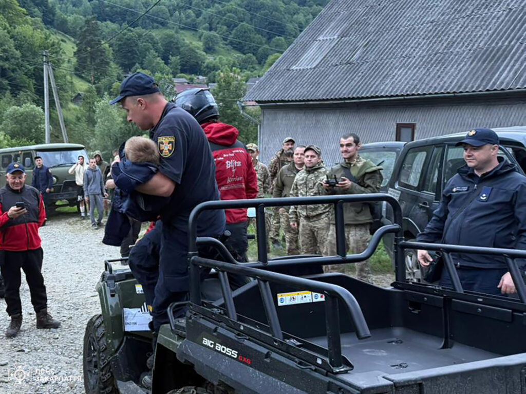Рятувальники допомагають малюку на машині в селі.