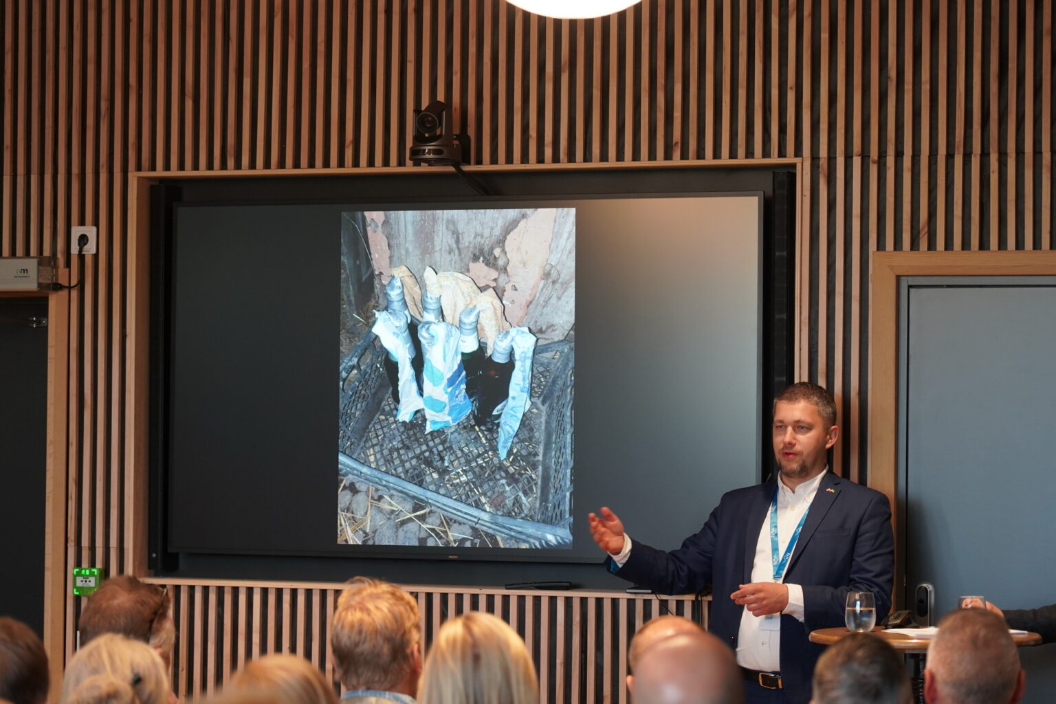 Чоловік презентує зображення на екрані перед аудиторією.