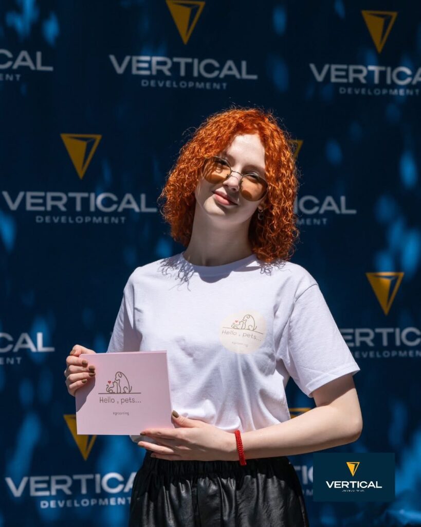 Людина з листівкою на фоні бренду Vertical.