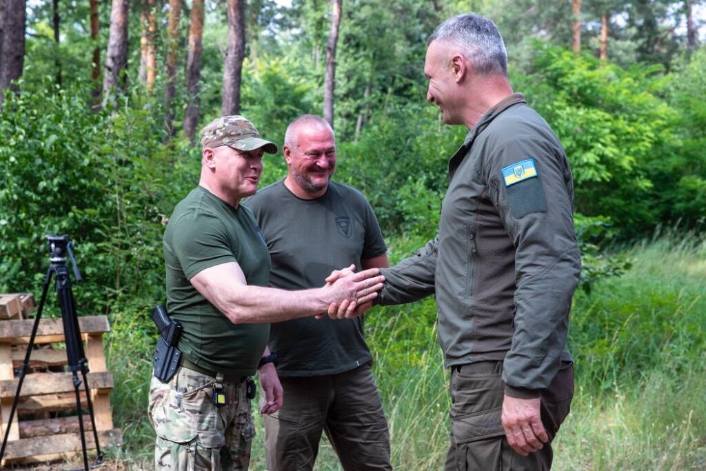 Військові чоловіки вітаються у лісі