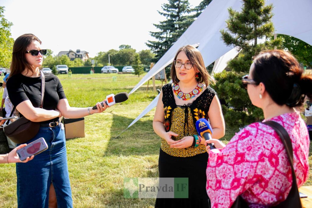 Журналісти беруть інтерв'ю в жінки на природі.