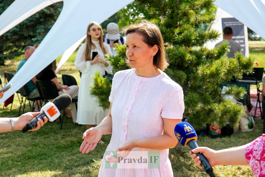 Жінка надає інтерв'ю на відкритому повітрі.