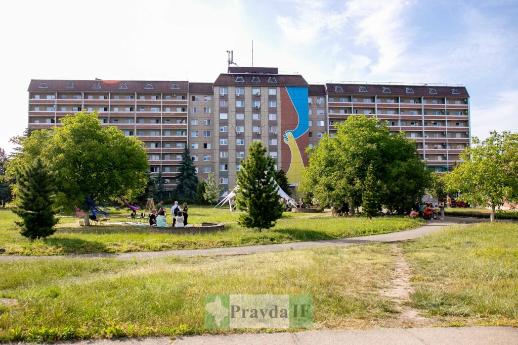 Великий житловий будинок з муралом і паркова зона.