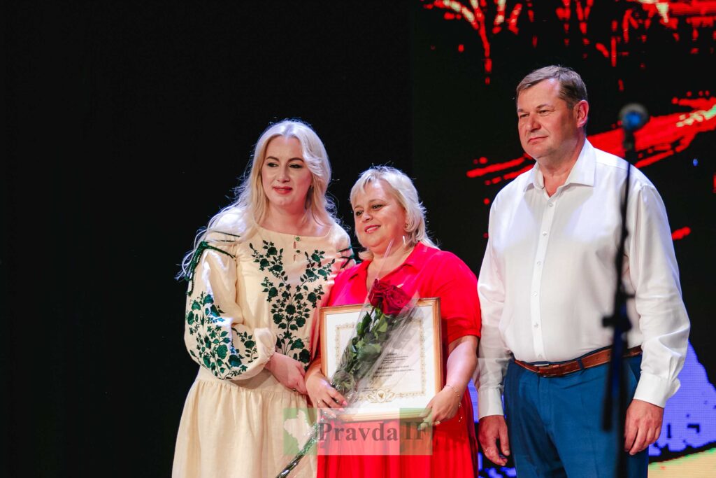 Нагородження жінки з квітами на сцені