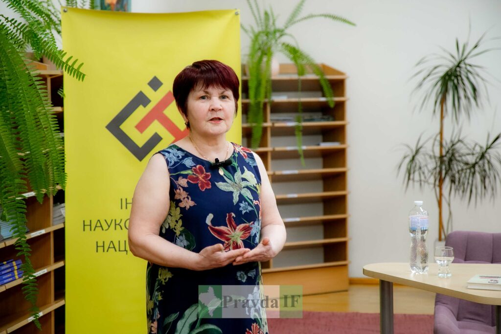Жінка виступає на науковій конференції з презентацією.
