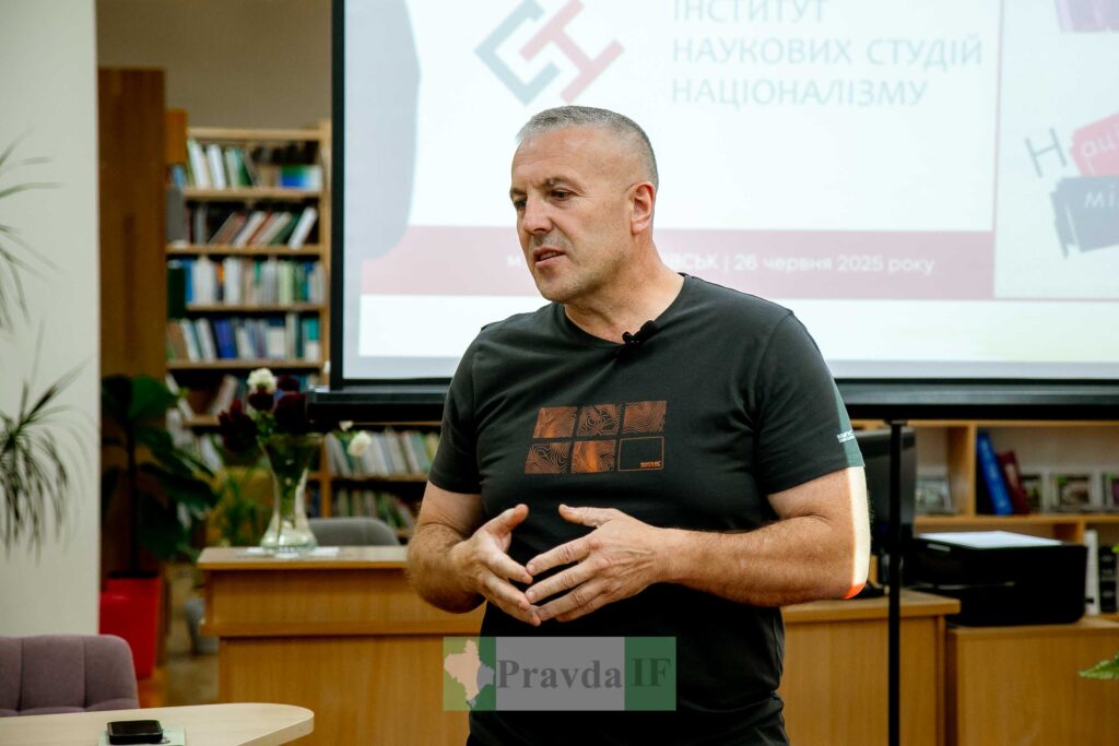 Чоловік говорить перед екраном у бібліотеці.