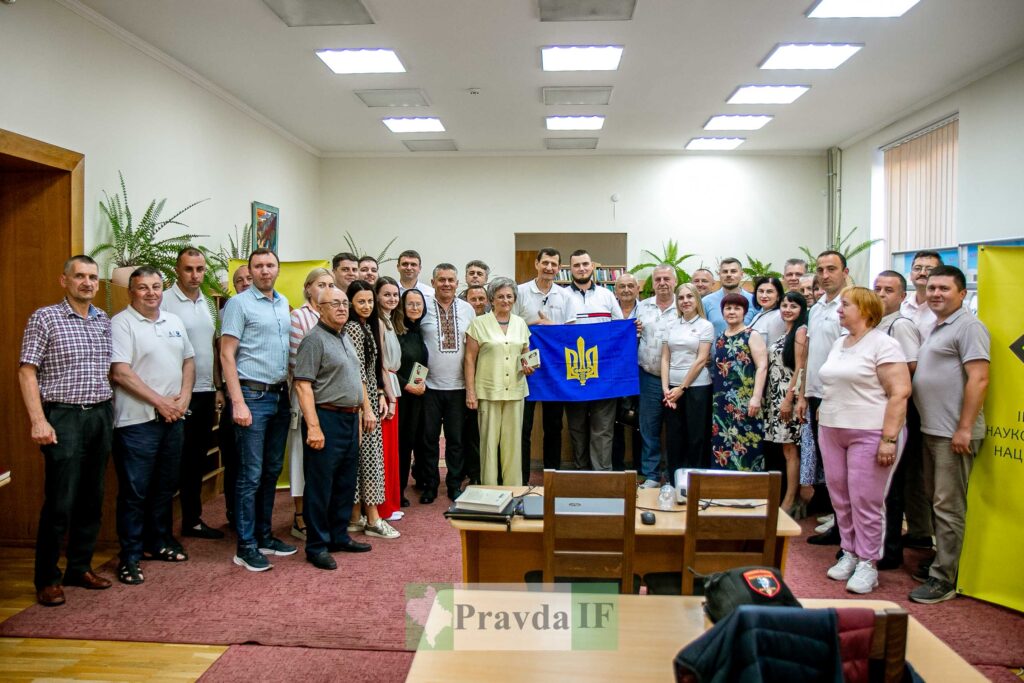 Групове фото з українським прапором у приміщенні.