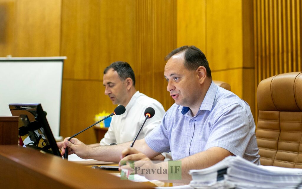 Двоє чоловіків виступають на засіданні у залі