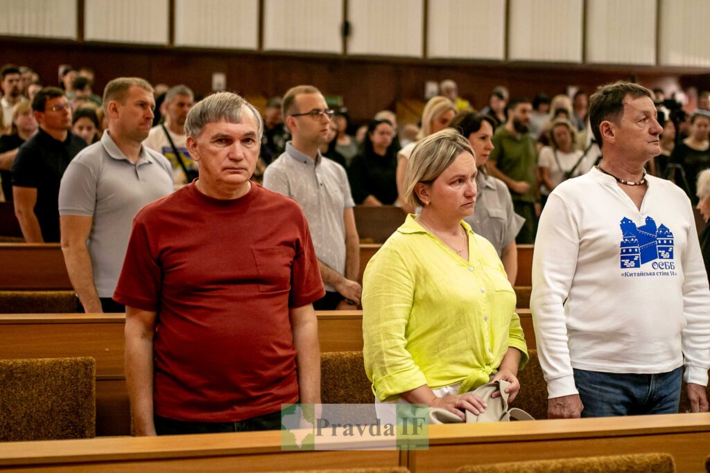 Люди стоять у залі під час заходу