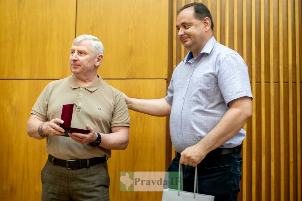 Чоловік отримує нагороду на церемонії в приміщенні.