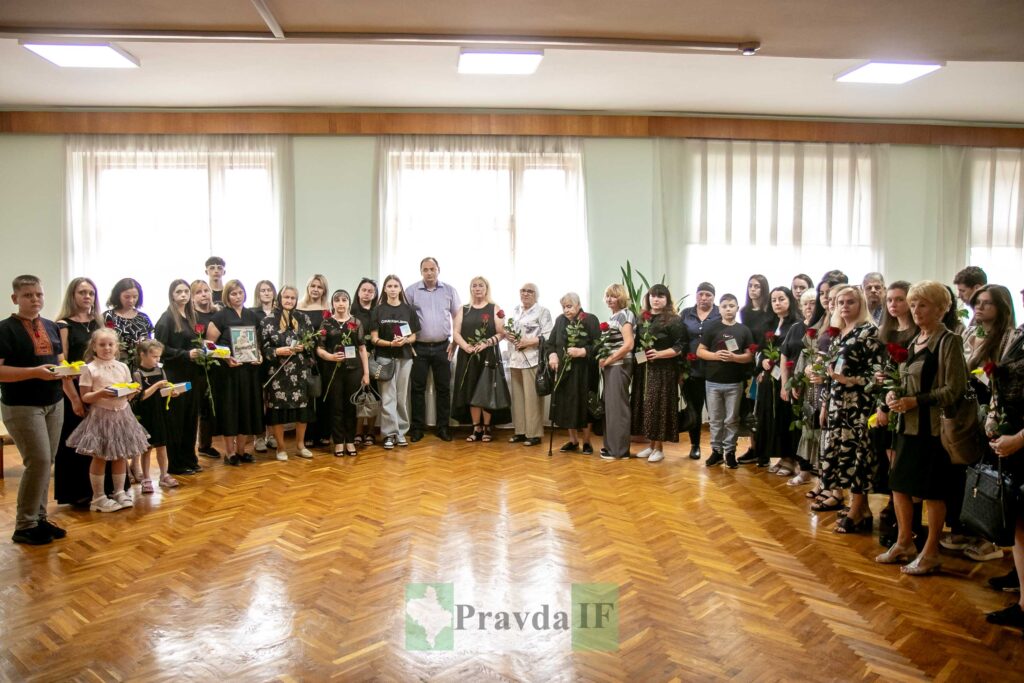 Групове фото людей з квітами в приміщенні.