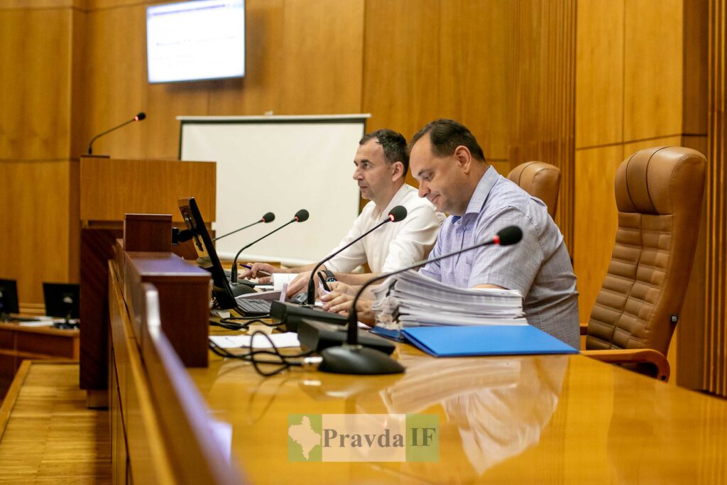 Двоє чоловіків обговорюють документи у залі засідань