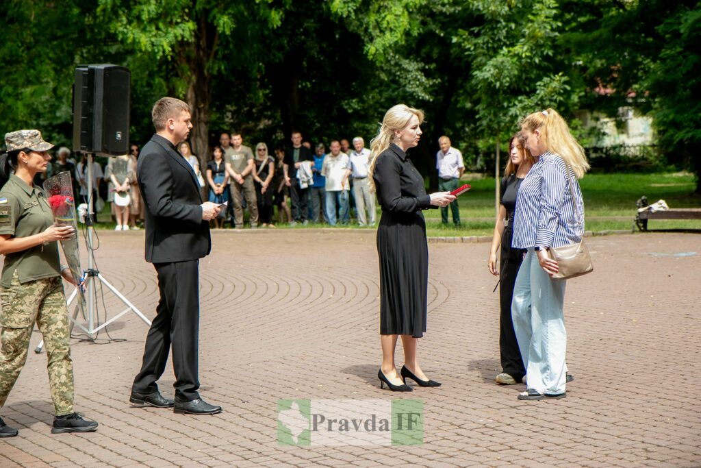 Вручення нагород у парку, присутні люди.
