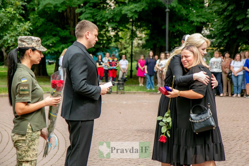 Церемонія нагородження у парку з військовими і квітами.