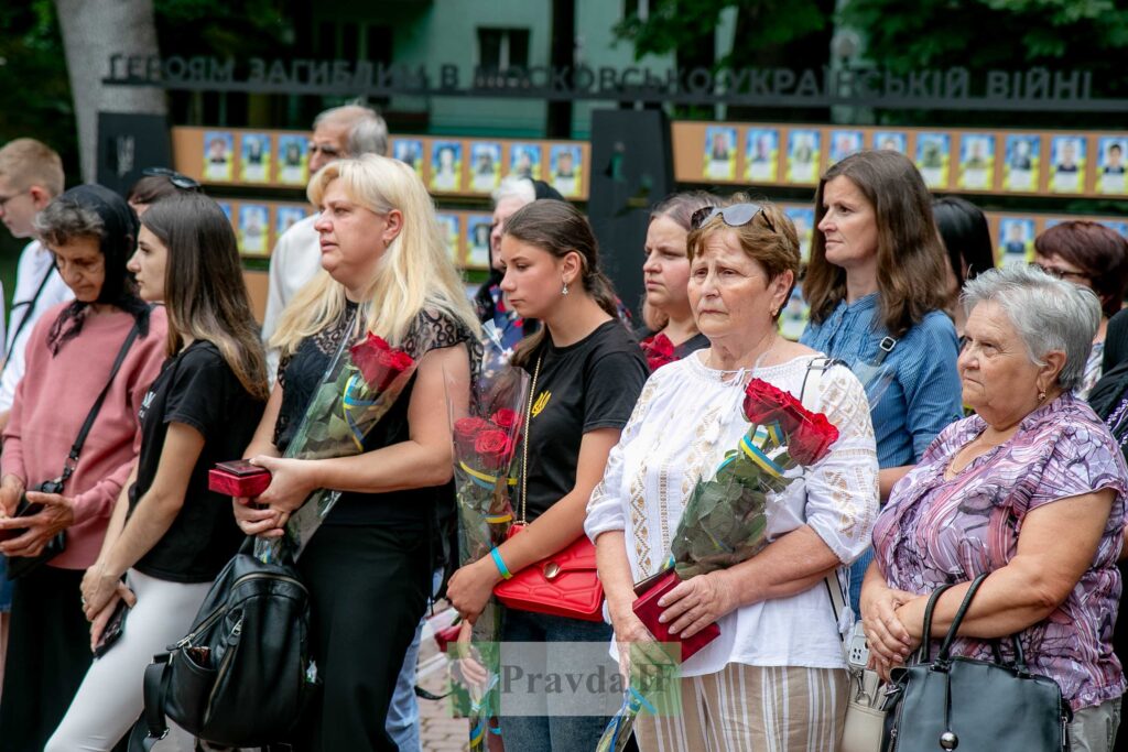 Люди з квітами на пам'ятній церемонії