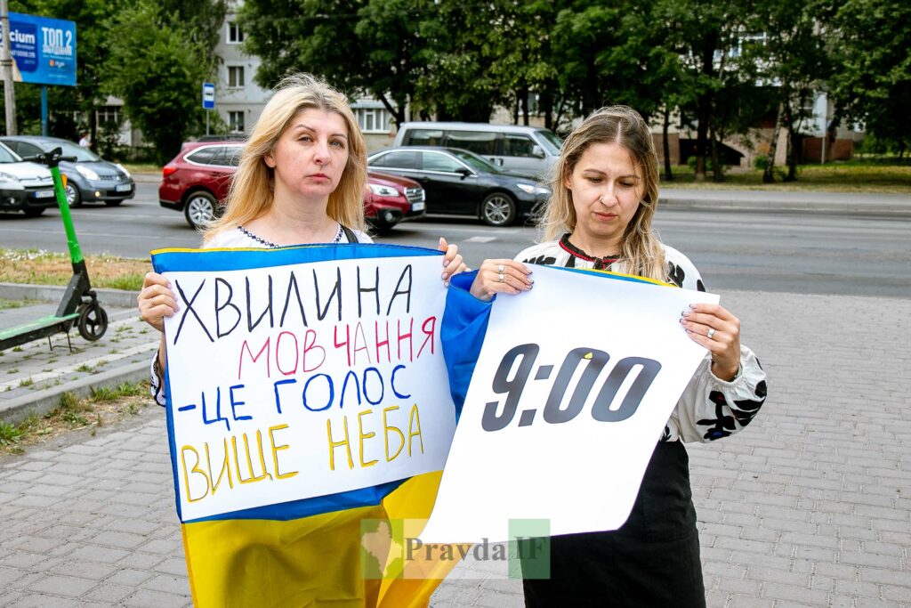 Дві жінки тримають плакати на вулиці.