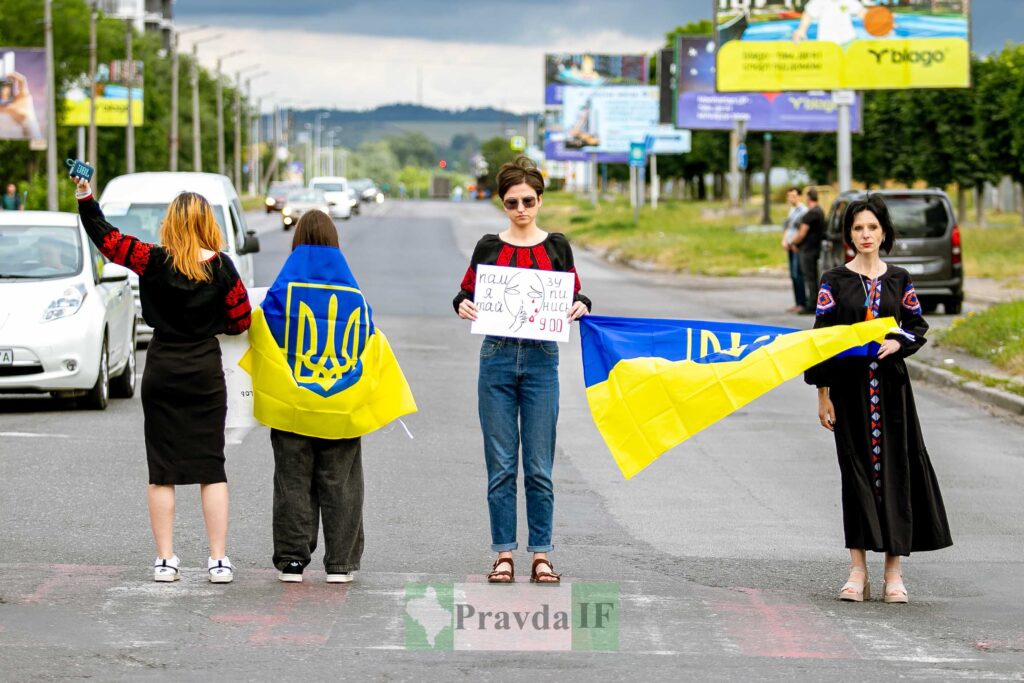 Люди з українськими прапорами на вулиці