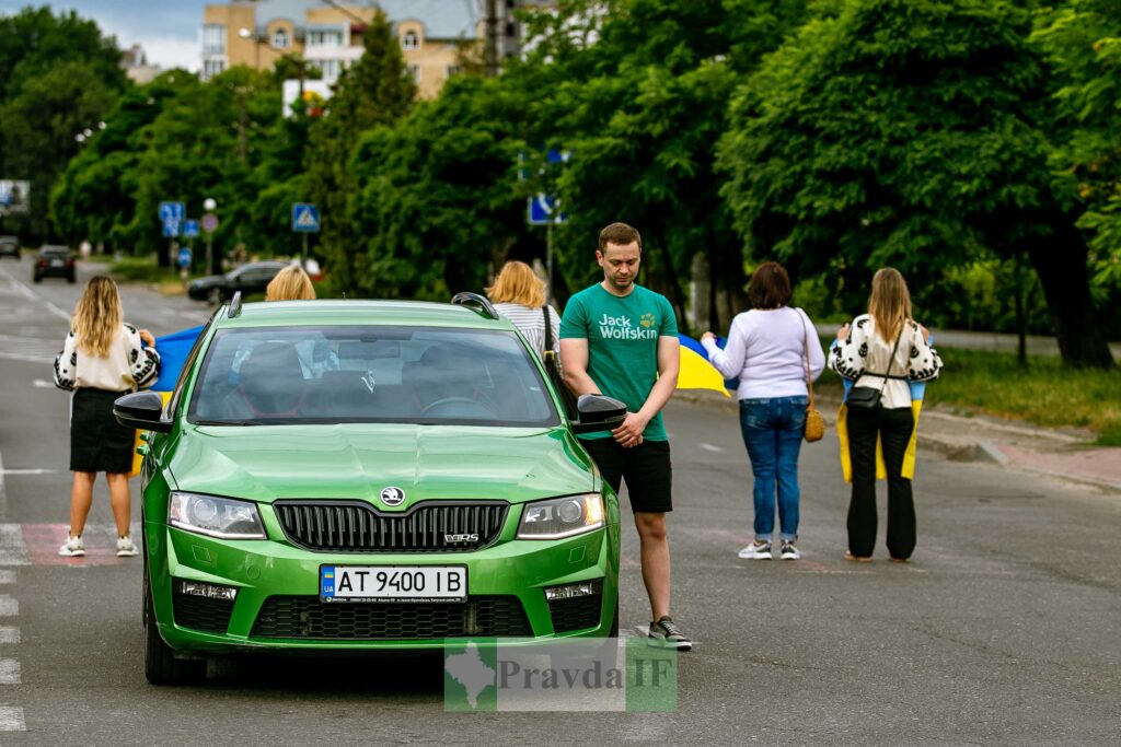 Люди блокують дорогу зеленим автомобілем.