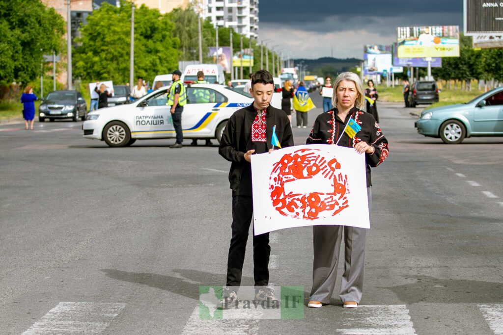 Люди з плакатом на вулиці під час демонстрації