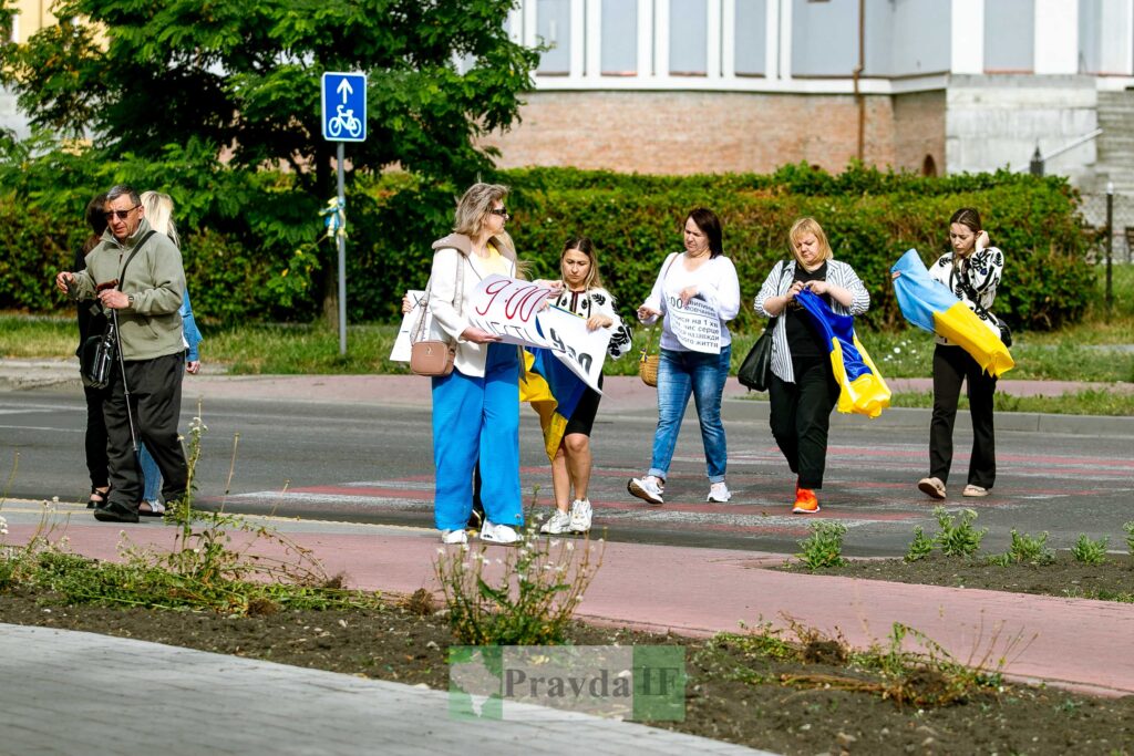 Люди з прапорами та плакатами на вулиці
