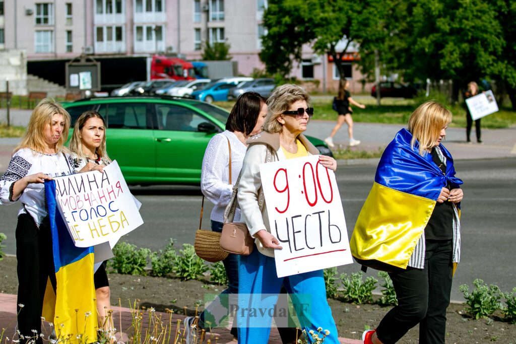 Люди тримають українські прапори та плакати на акції.