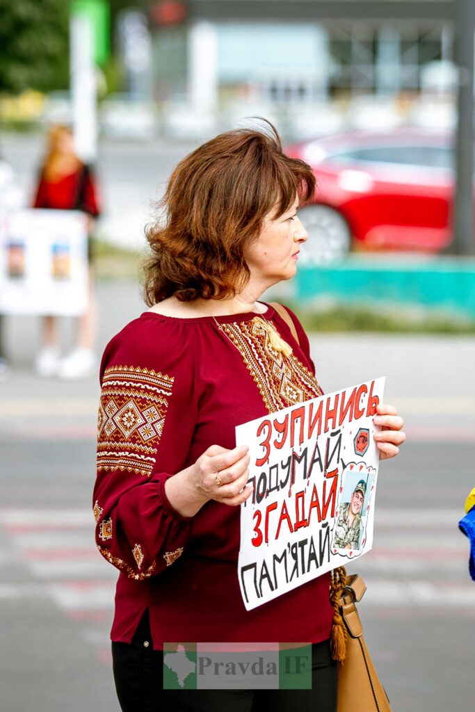 Жінка тримає плакат із закликом до пам'яті