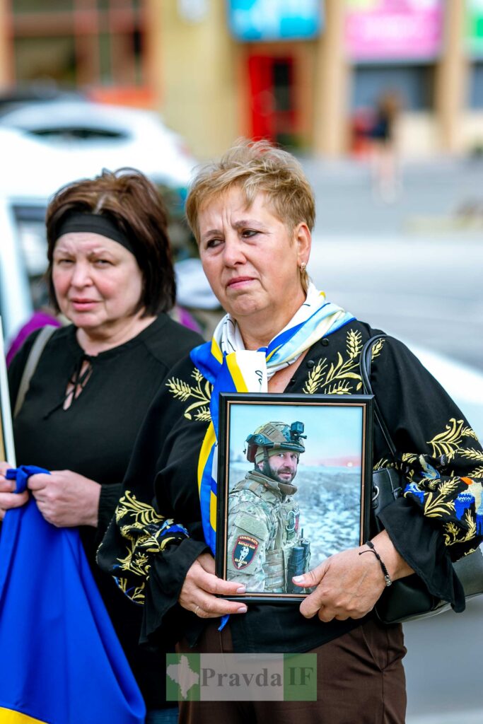 Жінки з фотографією українського військового на вулиці.